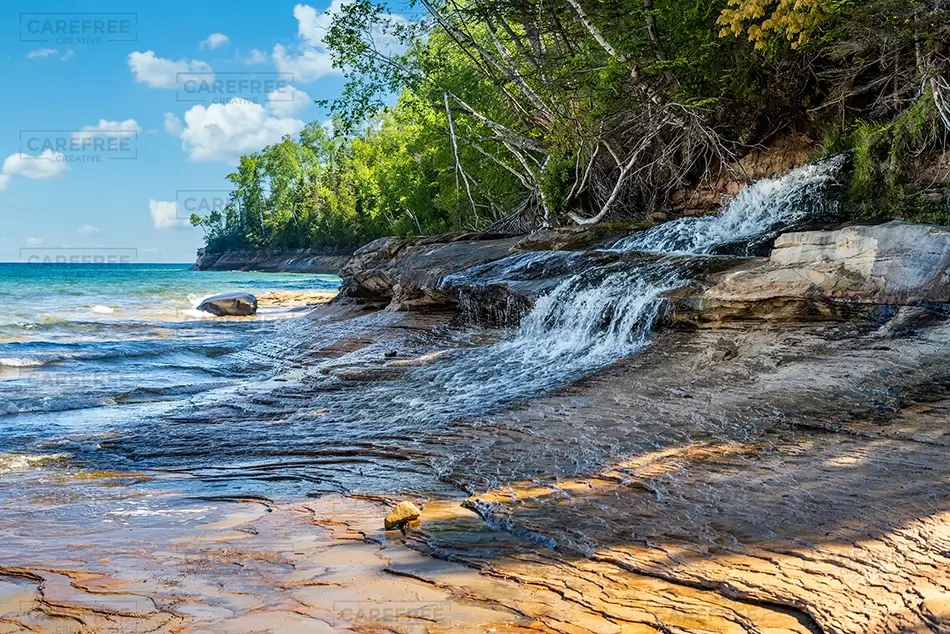Miners Beach Gentle Waterfall Amidst Rocky Shoreline